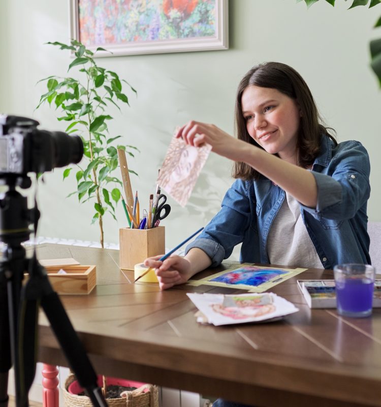 Creative girl teenager artist painting in watercolor