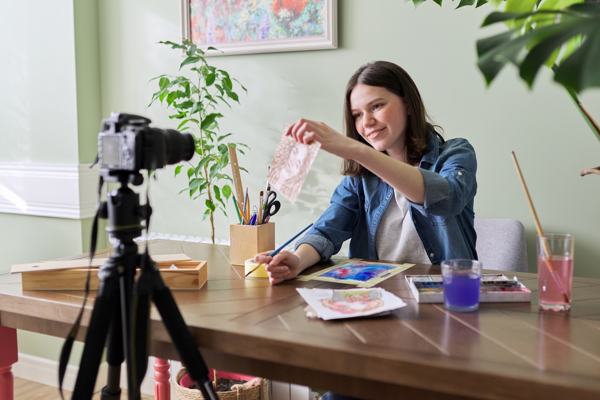 Creative girl teenager artist painting in watercolor